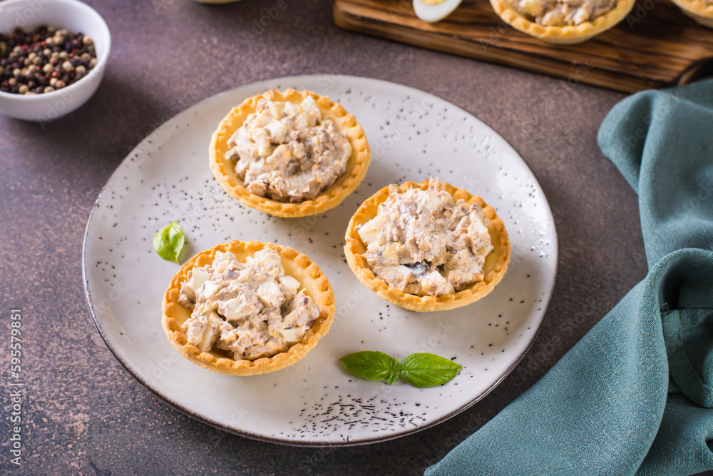 Tartlets filled with canned fish, eggs and mayonnaise on a plate Tartlets filled with canned fish, eggs and mayonnaise on a plate