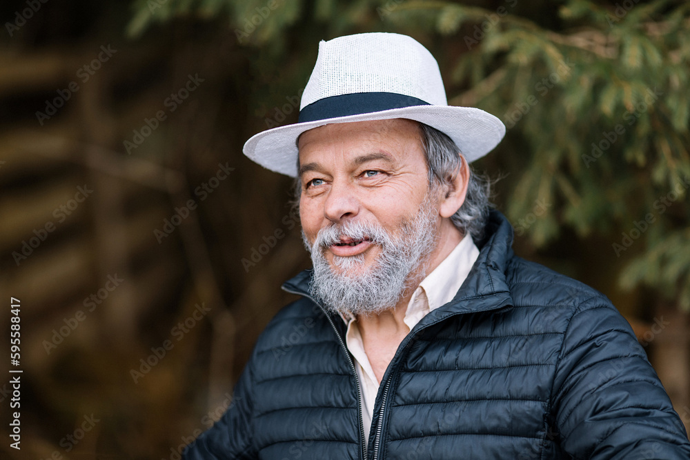 Portrait of a smiling, confident, handsome, mature man during his walk in the park Portrait of a smiling, confident, handsome, mature man during his walk in the park
