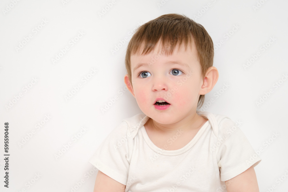 Surprised baby looks up with open mouth, studio white background. Amazed child with an emotion of surprise on his face. Kid about two years old (one year nine months) Surprised baby looks up with open mouth, studio white background. Amazed child with an emotion of surprise on his face. Kid about two years old (one year nine months)