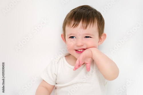 A happy baby on a studio white background. Portrait of a smiling child. Kid aged about two years (one year nine months)