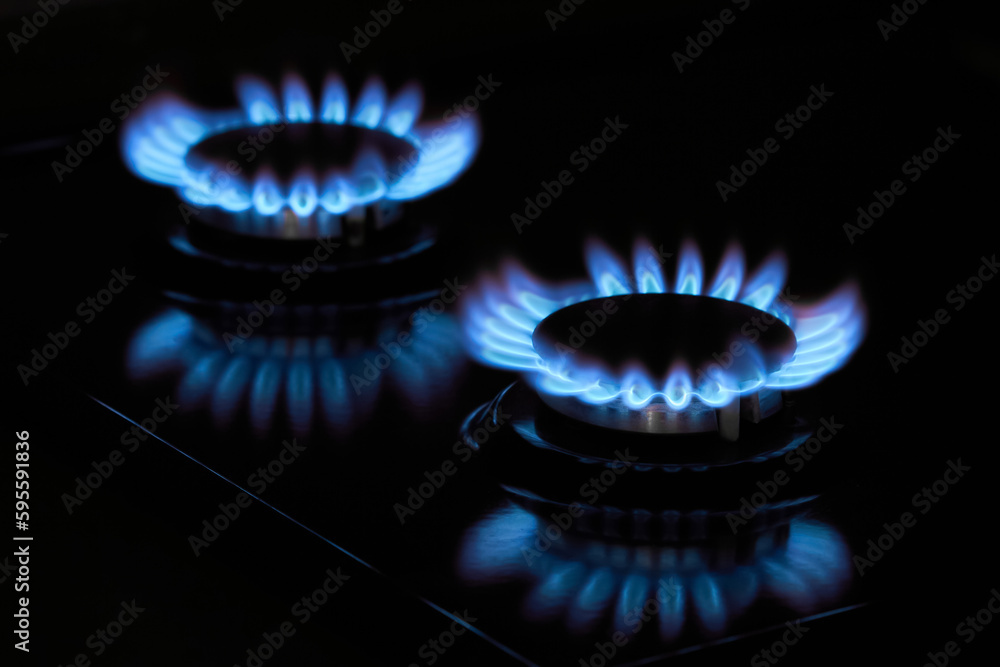 Flaming gas burners on household kitchen stove in the darkness Flaming gas burners on household kitchen stove in the darkness