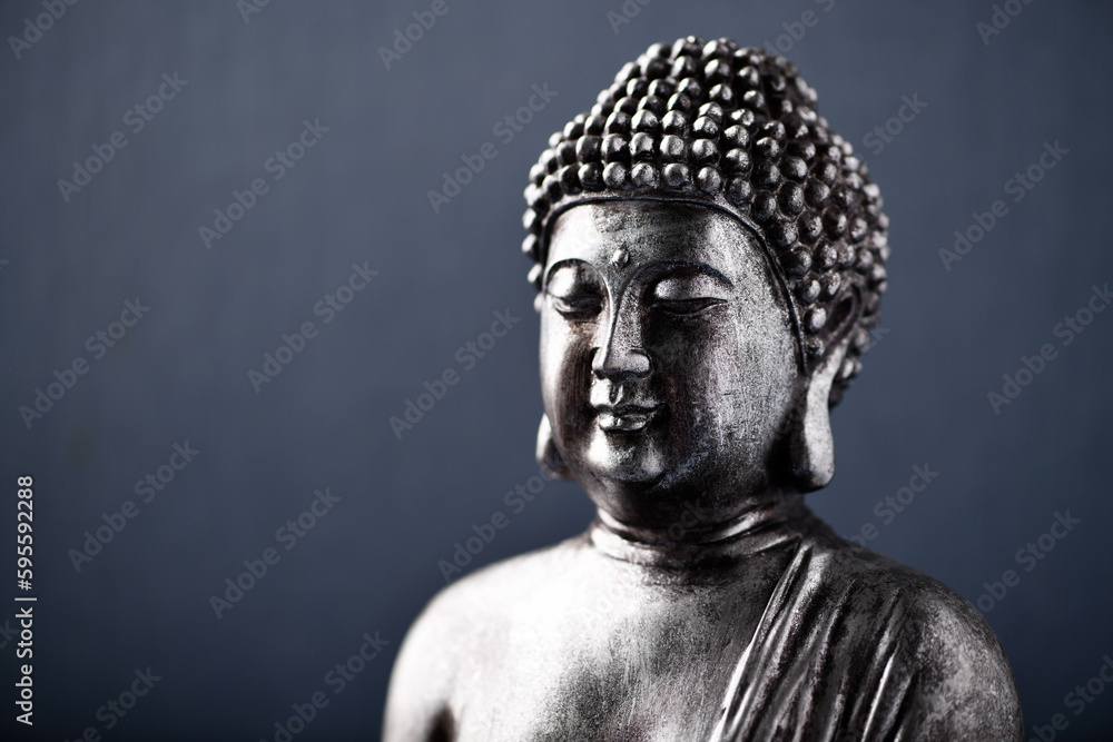 Meditating Buddha Statue on dark background. Soft focus. Close up. Copy space.