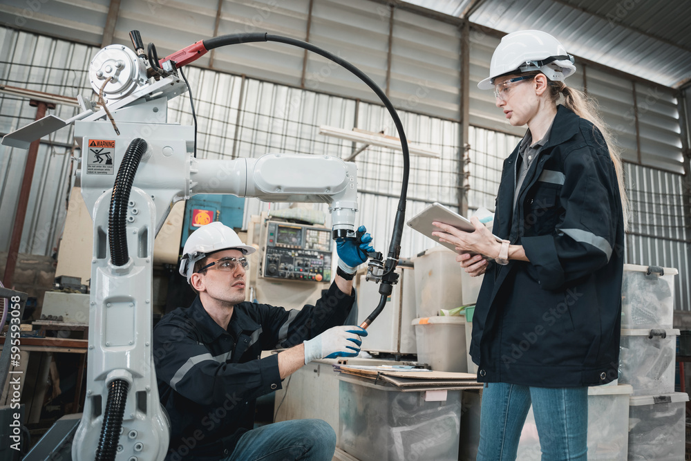 Industrial engineers are in charge of controlling the automated robot arms machine welding robots in industrial manufacturing factory. Industrial engineers are in charge of controlling the automated robot arms machine welding robots in industrial manufacturing factory.