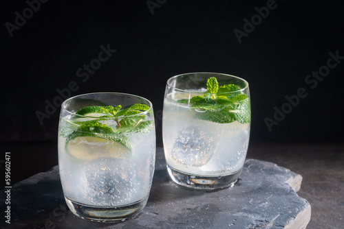 Cold summer lemonade with lime and mint, Cold fresh lemonade drink on a wooden table