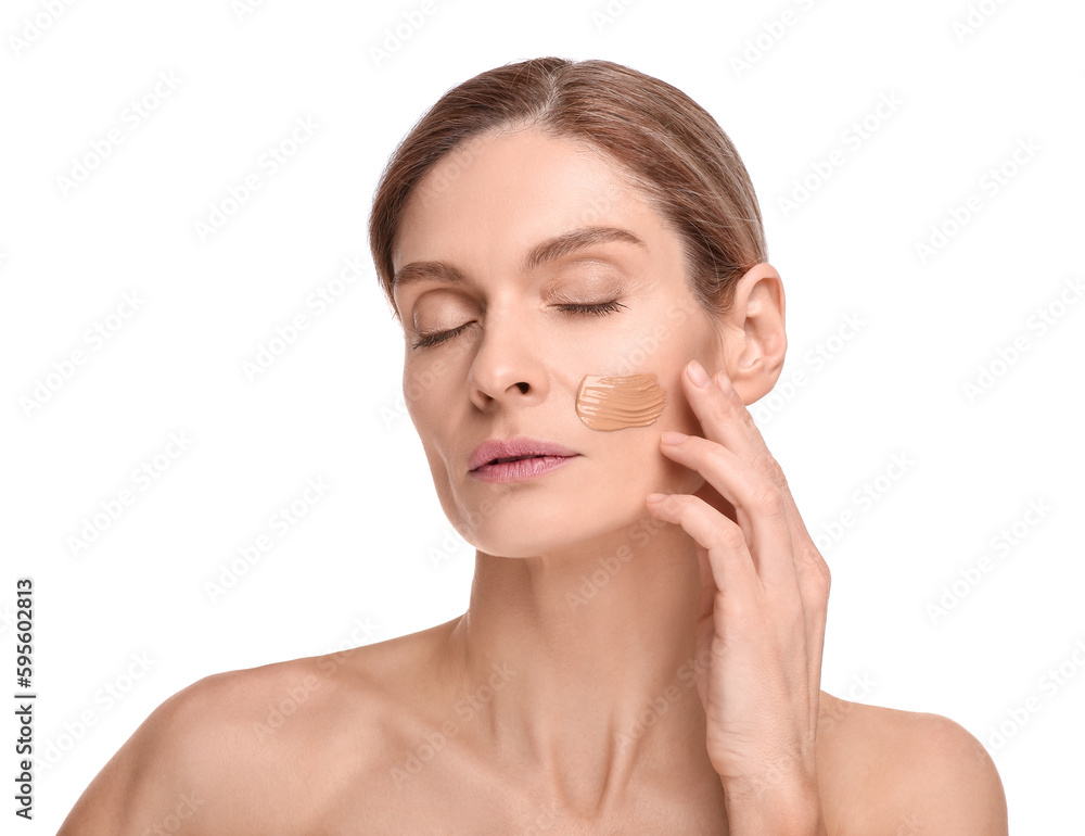 Woman with swatch of foundation on face against white background