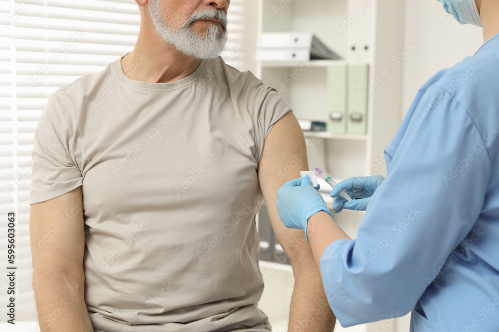 Obraz premium Doctor giving hepatitis vaccine to patient in clinic, closeup