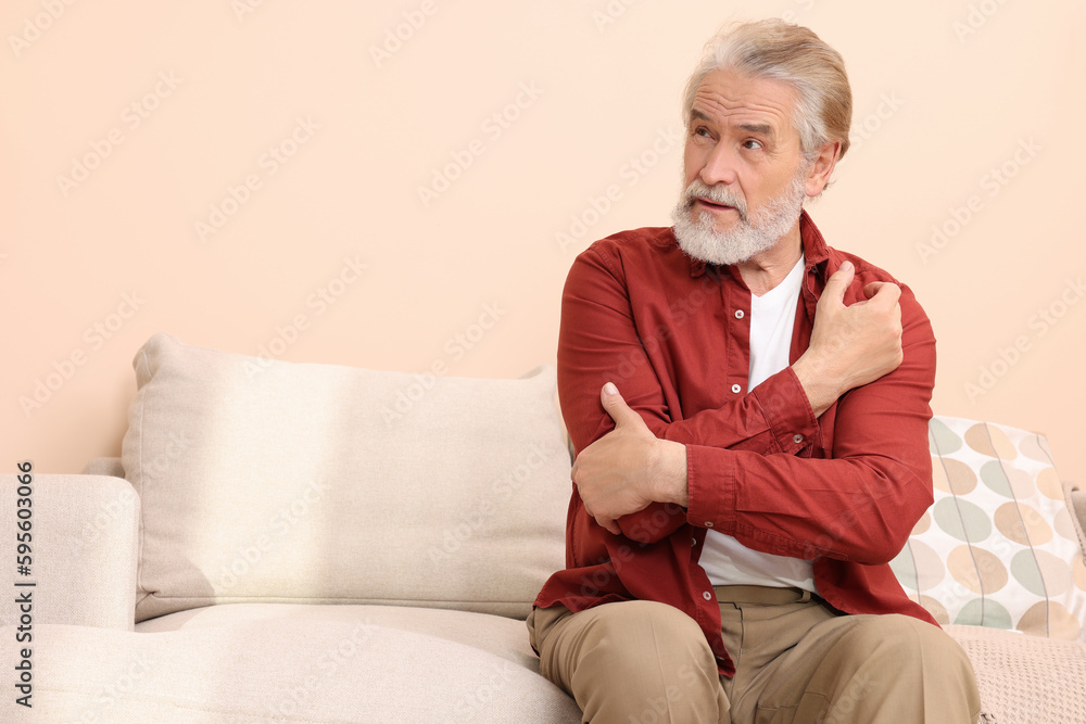 Senior man suffering from pain in his hand at home, space for text. Arthritis symptoms Senior man suffering from pain in his hand at home, space for text. Arthritis symptoms