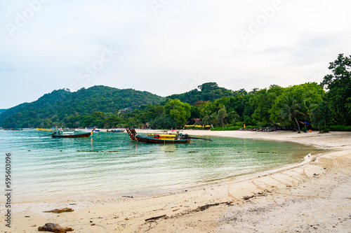 Long tailed boats near tropical beach at Ko Phi Phi, Thailand. Tropic beach with white sand and turquoise water, concept of vacation in paradise.