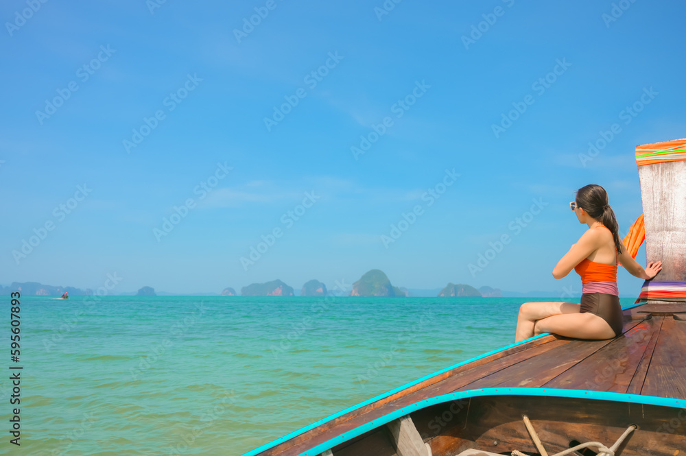 A woman sitting on a boat looking at the beautiful sea view.Krabi,Thailand