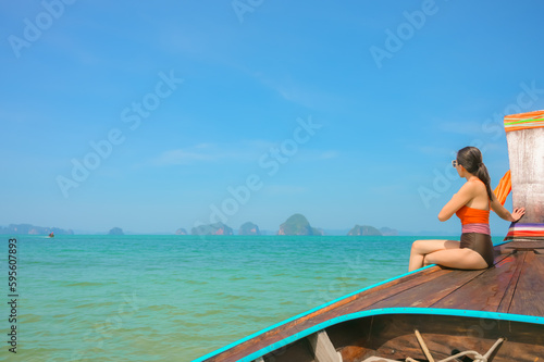 A woman sitting on a boat looking at the beautiful sea view.Krabi,Thailand © grooveriderz
