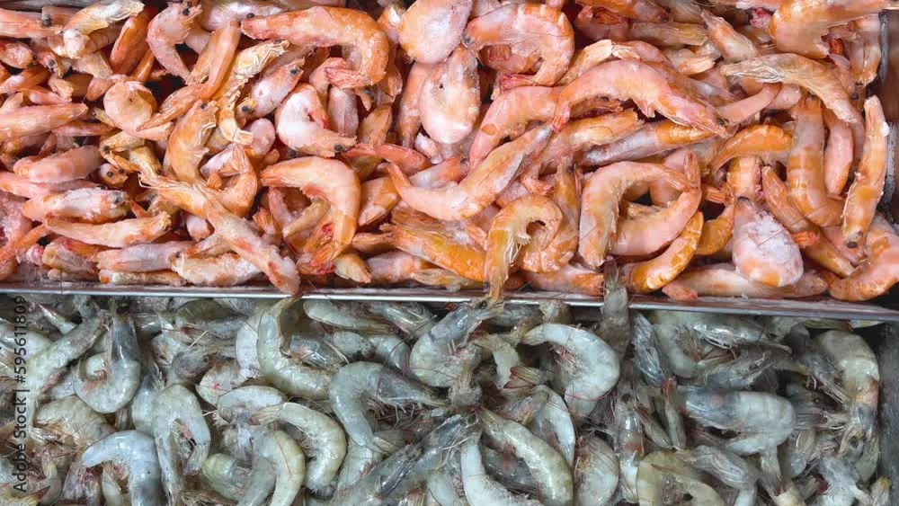 Bright orange cooked and gray raw shrimp in a metal container. Panorama. Fresh seafood on sale Bright orange cooked and gray raw shrimp in a metal container. Panorama. Fresh seafood on sale