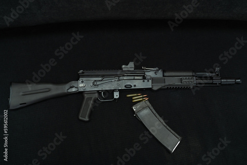 Assault weapon ak 105 and cartridges on a black background.