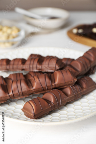 Tasty chocolate bars on white wooden table, closeup
