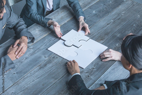 Team assembling jigsaw puzzle photo