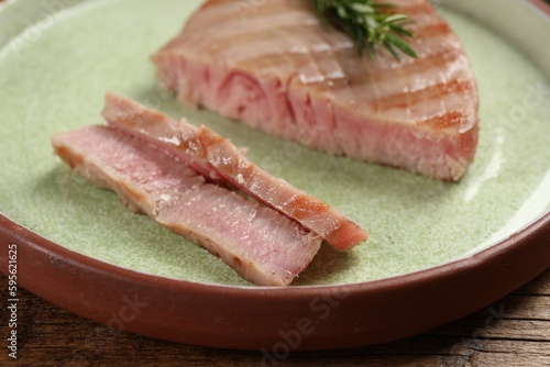 Delicious tuna steak on wooden table, closeup