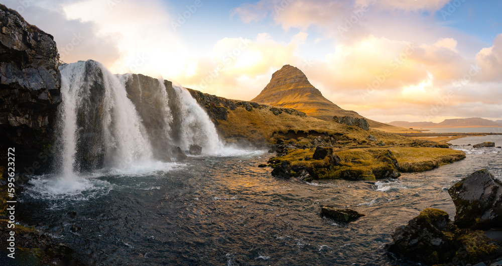 Fototapeta premium Stunning shot of Kirkjufell mountain in Iceland during a breathtaking sunset. The mountain's distinctive shape, combined with the vibrant colors of the setting sun, creates a magical moment.