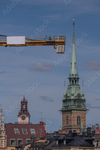 Church spires of the old town and a building crane arm, a sunny spring day in Stockholm