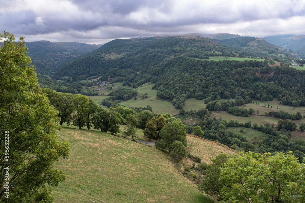 Country landscape in Auvergne, France with mountains, forests and fields for agriculture
