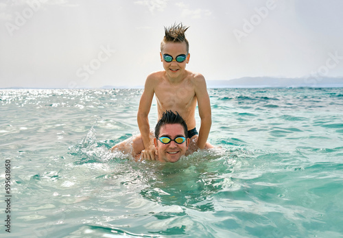 Happy family, father and son bonding, swim in the sea looking at view enjoying summer vacation. Togetherness Friendly concept  © Andrii IURLOV