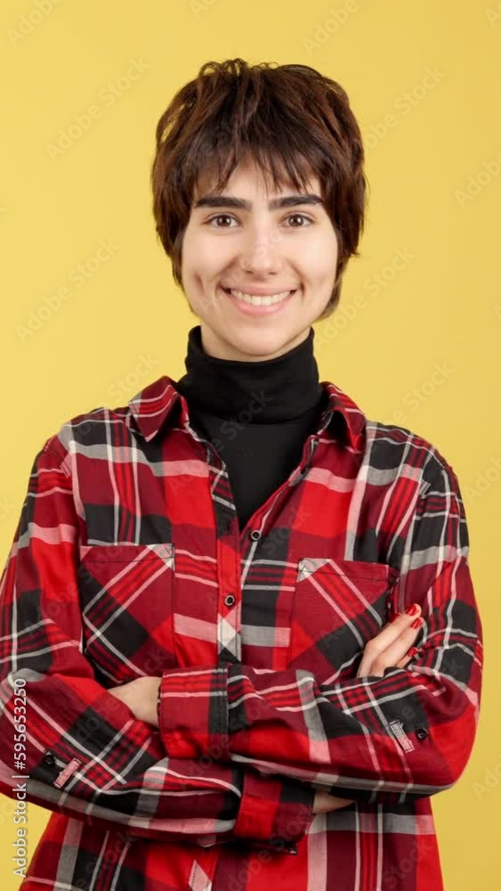 Androgynous person smiling at camera with arms crossed Androgynous person smiling at camera with arms crossed