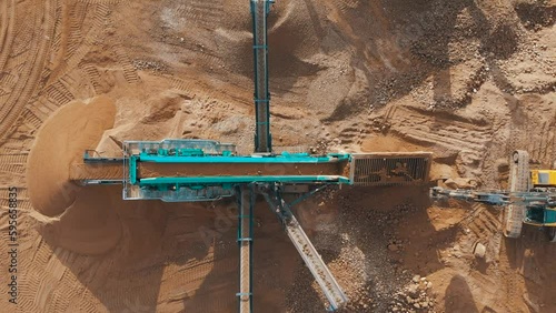 Sand Making Plant and Belt conveyor in mining quarry. Mining truck unload sand in stone crushing plant. Haul truck in opencast. Sand crushing plant. Extracting rock in Open-pit mining, aerial view.