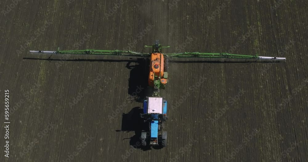 Field works. Tractor spraying on field with sprayer, herbicides and pesticides. Farm machinery spraying insecticide to the field. Modern agroculture at drone view. Field works. Tractor spraying on field with sprayer, herbicides and pesticides. Farm machinery spraying insecticide to the field. Modern agroculture at drone view.