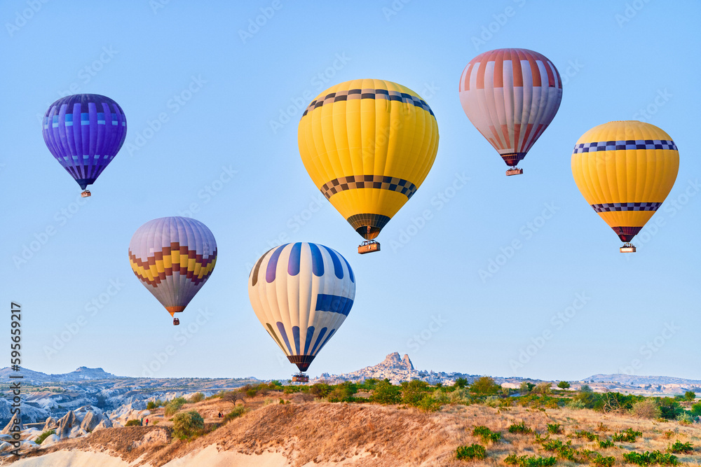 Obraz premium Landscape of colorful flying hot air balloons in Anatolia, Kapadokya at sunrise. National park in Nevsehir, Goreme