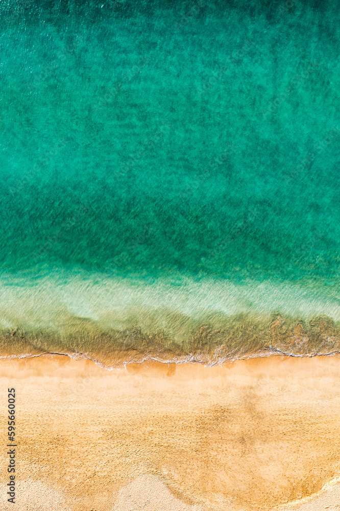 Beach with turquoise water on Fuerteventura island, Spain, Canary islands. Aerial view of sand beach, ocean texture background, top down view of beach by drone. Fuerteventura, Spain, Canary islands.