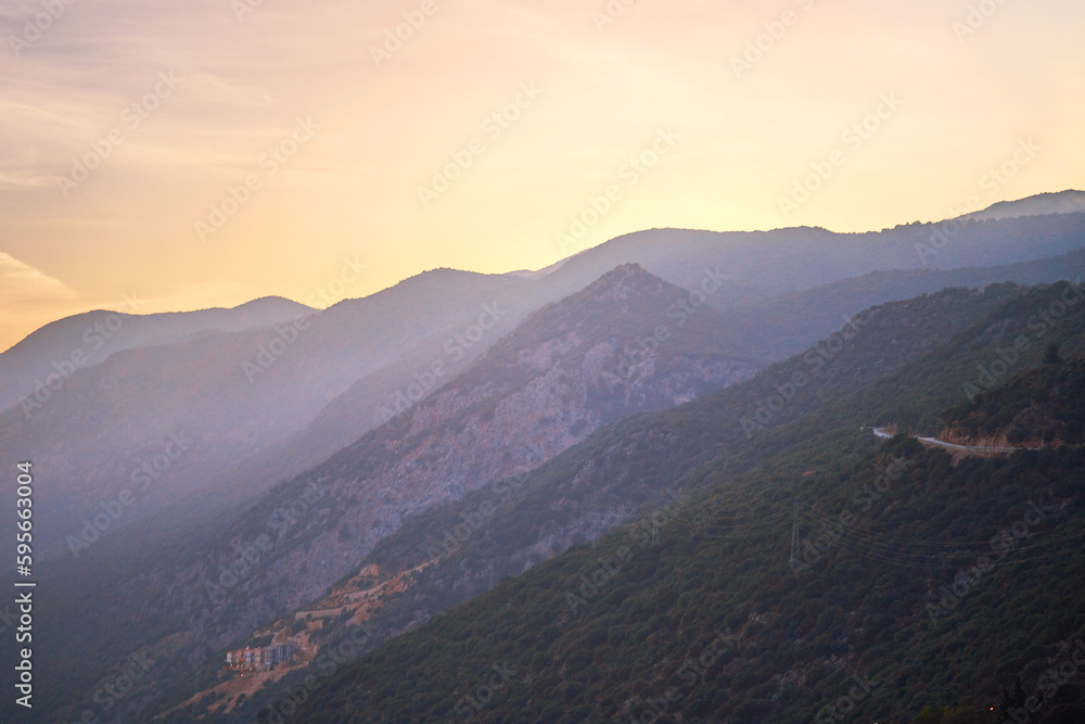 Landscape of mysterious misty idyllic mountains with haze at sunset with soft light