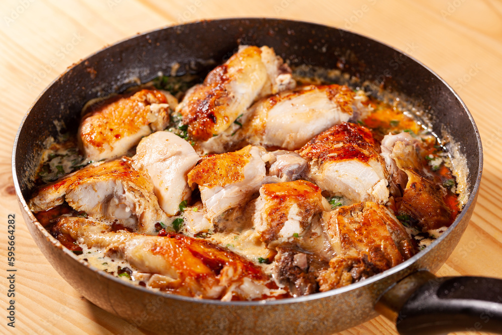 Shkmeruli, chicken in garlic sauce on a frying pan