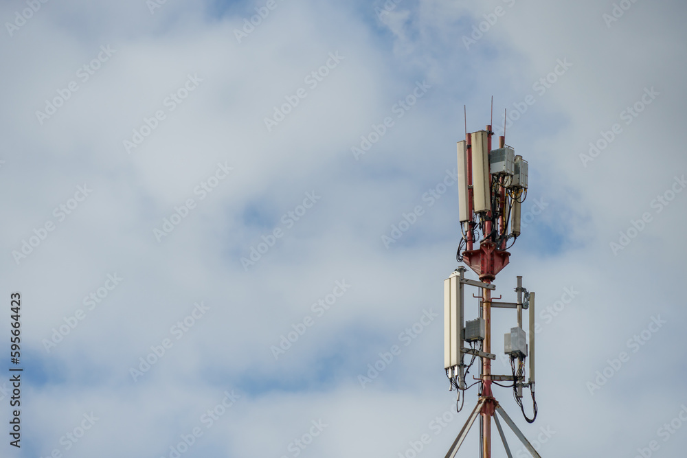 New GSM antennas on a tower against a blue sky for transmitting a 5g signal are dangerous. Radiation pollution of the environment through cell towers. New technologies in the field of communication.