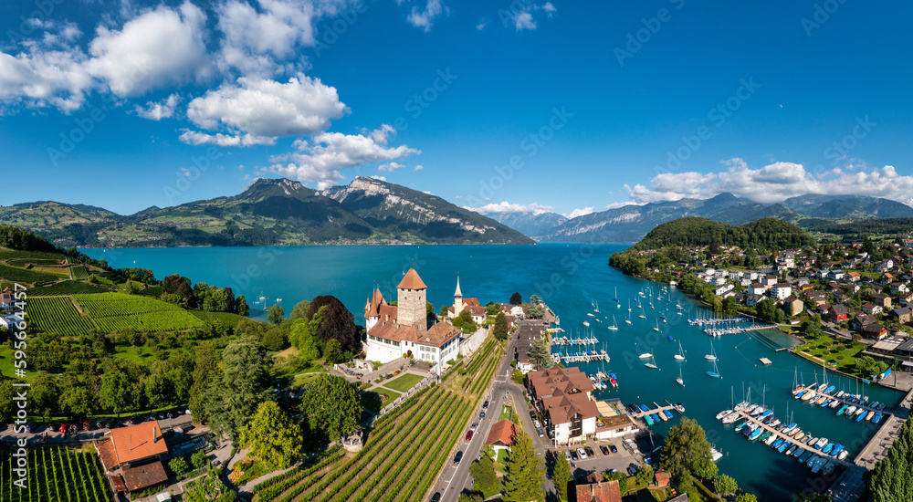 Aerial panoramic view of Spiez Church and Castle on the shore of Lake Thun in the Swiss canton of Bern at sunset, Spiez, Switzerland. Spiez Castle on lake Thun in the canton of Bern, Switzerland.