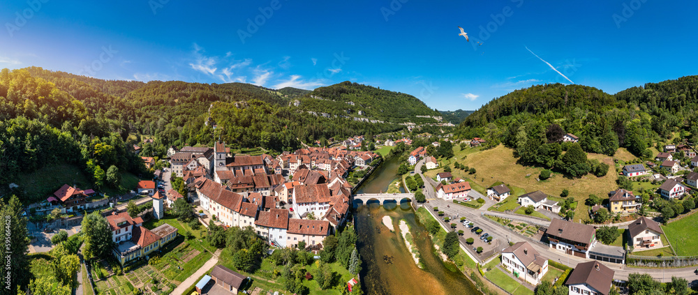 Fototapeta premium Picturesque Swiss village of Saint-Ursanne on the Doubs River, Switzerland. Village Saint-Ursanne in the district of Porrentruy in the canton of Jura, Switzerland. Saint Ursanne, Jura, Suisse