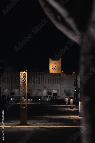 clock tower shining bright yellow in the middle of the old city at night, middle east, Doha, qatar