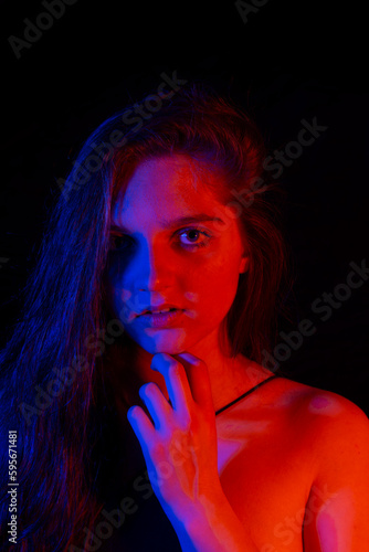 face of girl on a dark background with colored lights