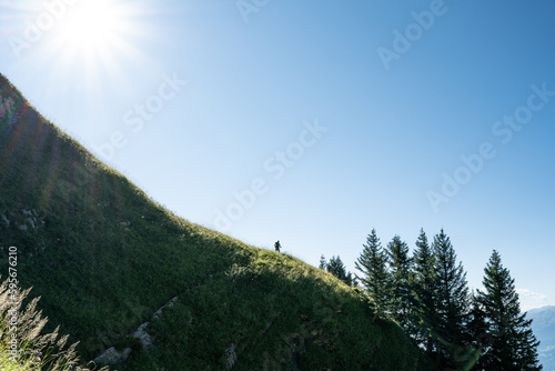 Sportive woman hikes up steep slope from Walensee to Churfürsten in the morning. Schnürliweg, Walensee, St. Gallen, Switzerland, Europe. photo