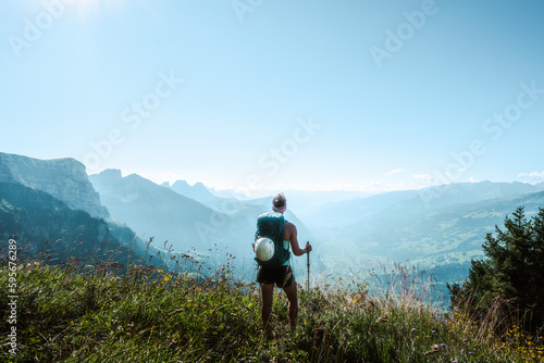 Athletic woman enjoys the view from a vantage point on the Walensee in the morning. Schnürliweg, Walensee, St. Gallen, Switzerland, Europe.