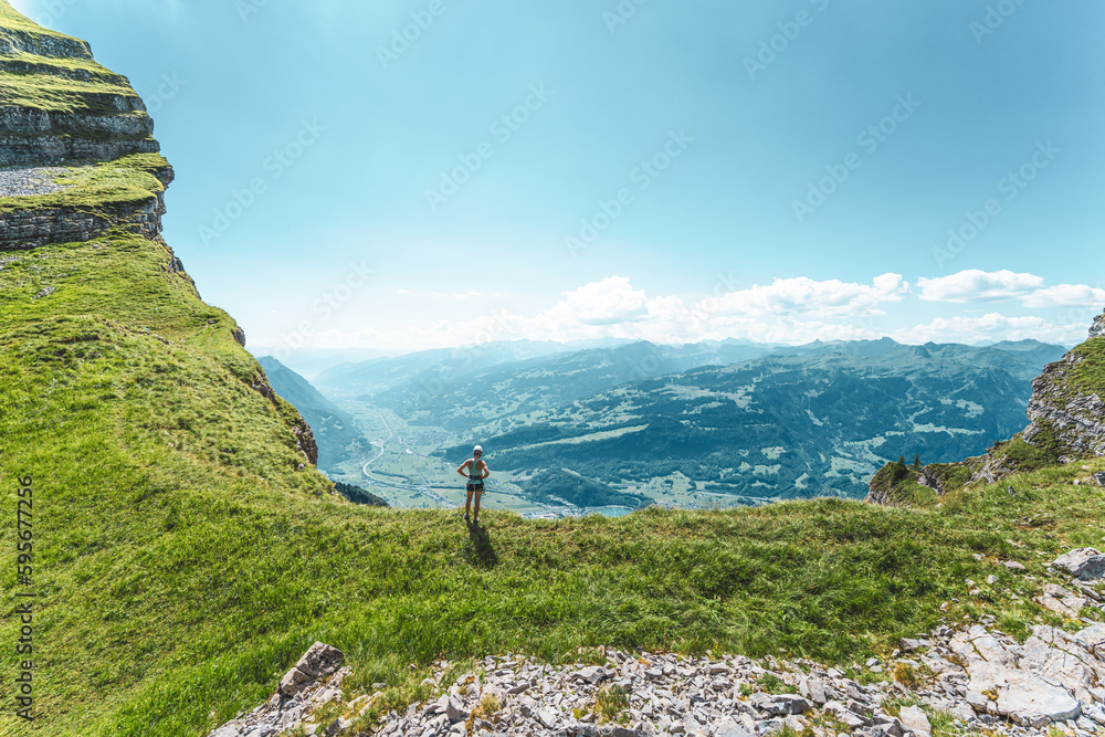 Sporty woman enjoys amazing view from Churfürsten hike trail on lake Walensee. Schnürliweg, Walensee, St. Gallen, Switzerland, Europe.
