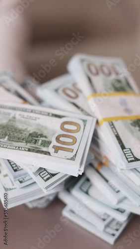 A woman's hand takes bundles of dollars