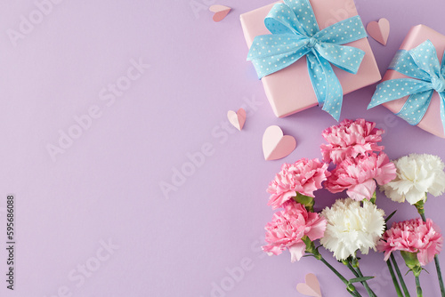 Tenderness and love for mom concept. Top view photo of gift boxes bunch of carnation flowers and paper hearts on light violet background. Flat lay with for text or greeting message
