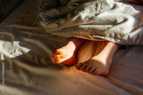 child's barefeet under blanket in the early morning light