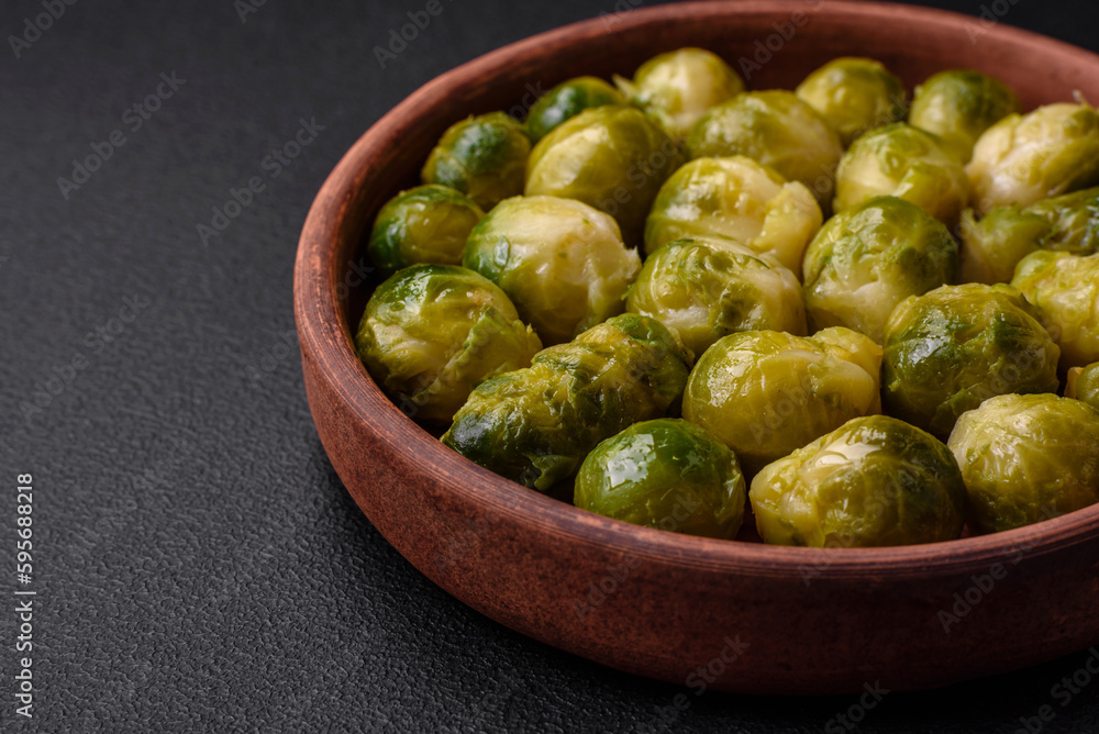 Delicious boiled Brussels sprouts on a ceramic plate on a dark concrete background Delicious boiled Brussels sprouts on a ceramic plate on a dark concrete background