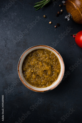 Tkemali sauce from green plums in a small ceramic bowl.