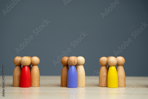 Groups of multicolored wooden people on a gray background. The concept of market segmentation. Target audience, customer care. Market group of buyers. Customer relationship management. Selective focus photo
