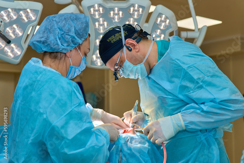 plastic surgeon operates on a patient in the operating room