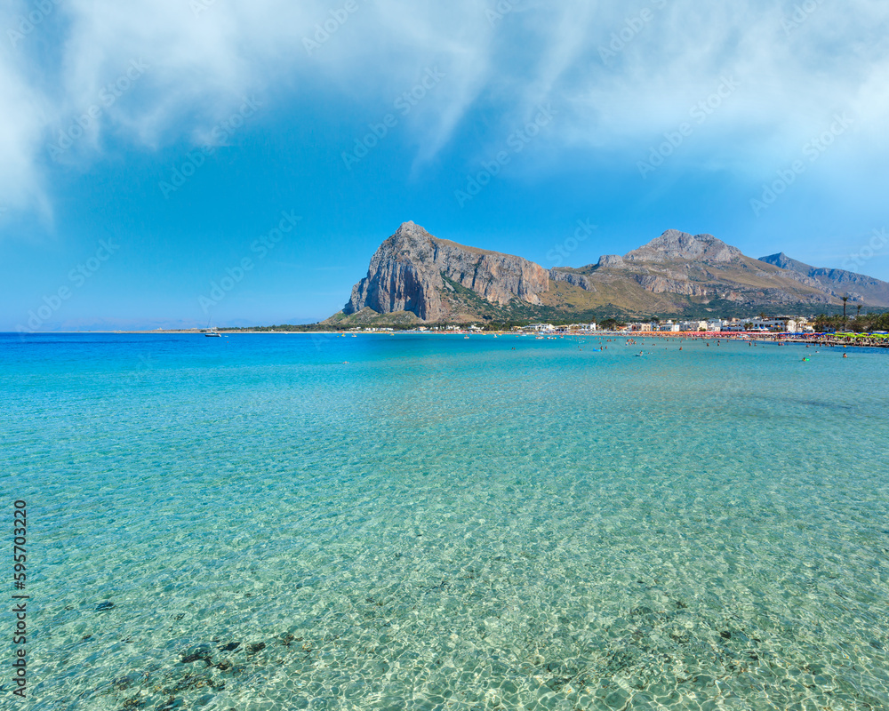 Paradise Tyrrhenian sea bay, San Vito lo Capo beach with clear azure water and extremally white sand, and Monte Monaco in far, Sicily, Italy. People unrecognizable.