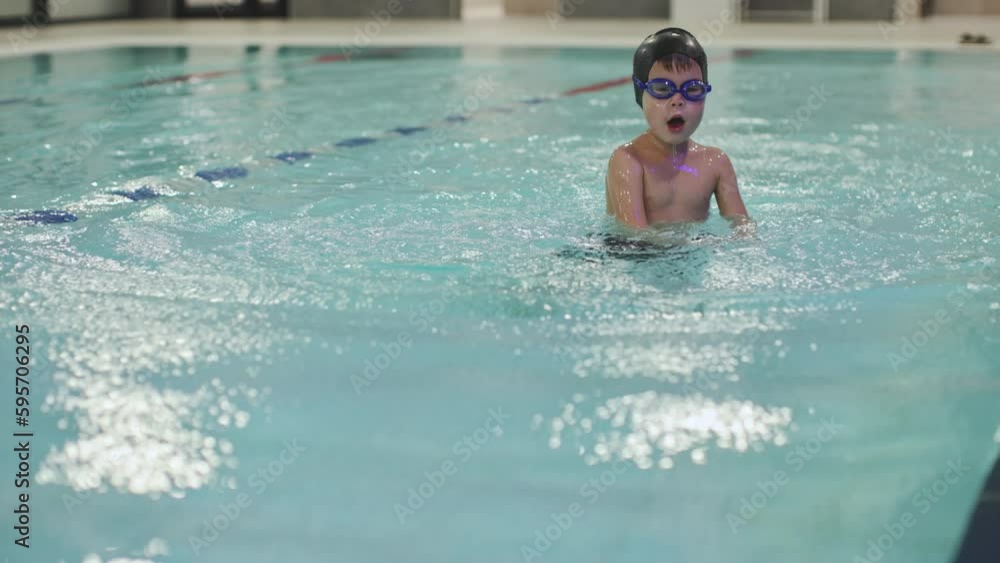 swimming class preschooler boy kid training crawl technique swim on stomach learn hand moves and