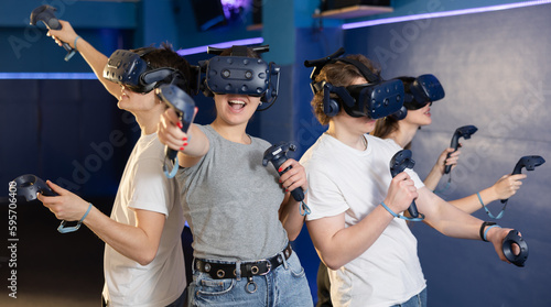 group of four friends wearing virtual reality glasses and with joysticks are playing dynamic game. High quality photo