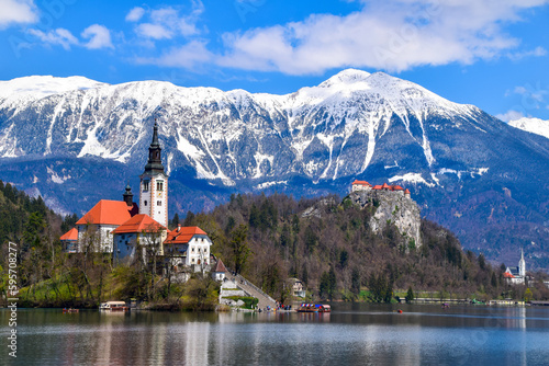 Famous alpine Bled lake (Blejsko jezero) in Slovenia, amazing autumn landscape. Scenic view of the lake, island with church, Bled castle, mountains and blue sky with clouds, outdoor travel background