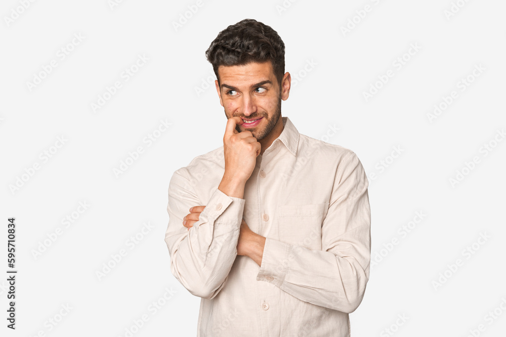 Young handsome man isolated relaxed thinking about something looking at a copy space. Young handsome man isolated relaxed thinking about something looking at a copy space.